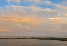 Obedience: the true remedy to worldly anxiety A rainbow with multi-coloured clouds over an island and busy small harbour