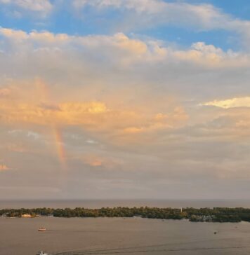 Obedience: the true remedy to worldly anxiety A rainbow with multi-coloured clouds over an island and busy small harbour