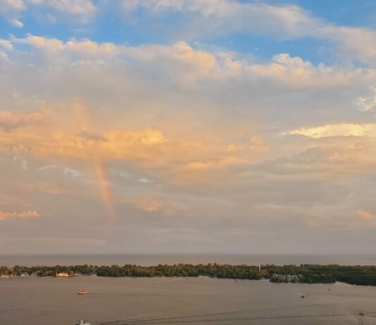Obedience: the true remedy to worldly anxiety A rainbow with multi-coloured clouds over an island and busy small harbour