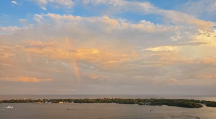 Obedience: the true remedy to worldly anxiety A rainbow with multi-coloured clouds over an island and busy small harbour