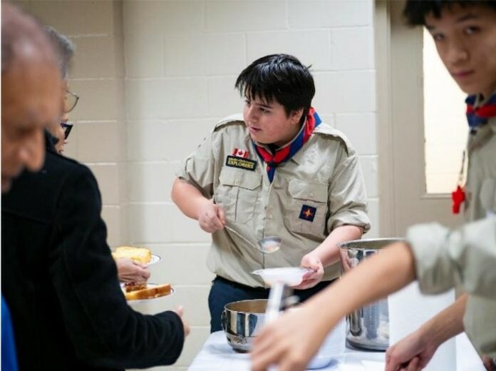 FNE St Thomas the Apostle, 2026 A young explorer serves senior parishioners in a Church hall