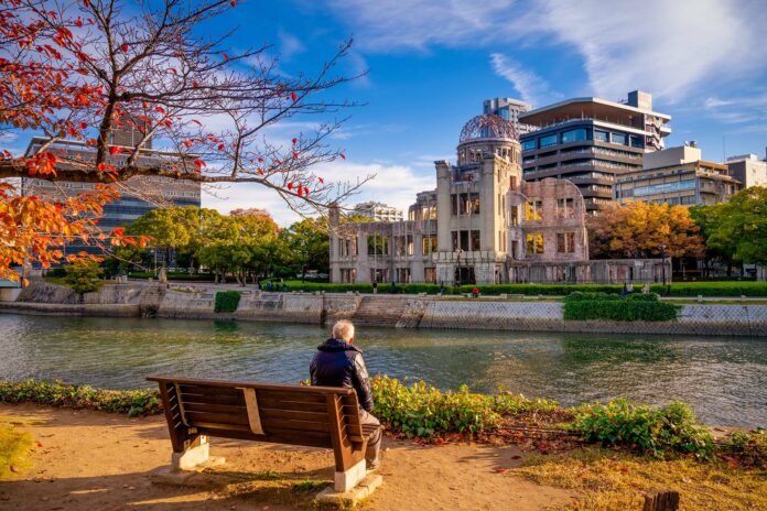 Senior man looking at Hiroshima Peace Memorial building in Japan
